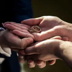 Dłonie trzymające dwie obrączki. Czy trzeba mieć obrączki na ślubie cywilnym? To pytanie zadaje sobie wiele par.