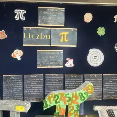 Tablica z okazji Dnia Liczby Pi, z dekoracjami w kształcie symbolu π, pizzy i koniczyny. Widać napisy "Liczba π" i "Ciekawostki o liczbie Pi".