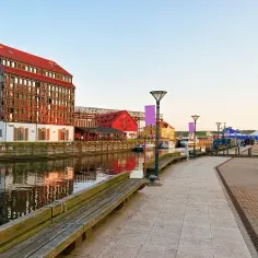 Nadbrzeże w Kłajpedzie, największym mieście Małej Litwy, z nowoczesnym budynkiem i statkami w tle.