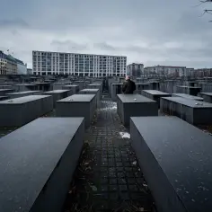 Pomnik Pomordowanych Żydów Europy w Berlinie. Betonowe bloki tworzą labirynt pamięci. Samotny mężczyzna kontempluje historię.