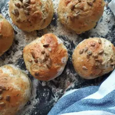 Sześć świeżych bułek do hamburgerów posypanych słonecznikiem, gotowych do tego, jak podgrzać bułki do hamburgerów w airfryer.