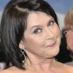 Uśmiechnięta kobieta z ciemnymi włosami, w eleganckich kolczykach. Czy to efekt jaworowicz operacje plastyczne?