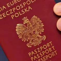 Dłoń trzyma polski paszport. Zastanawiasz się, ile paszport może leżeć w urzędzie? Czas oczekiwania bywa różny.