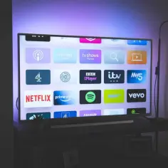 Telewizor z ikonami aplikacji streamingowych, jak Netflix. Zastanawiasz się, dlaczego zacina się obraz w telewizorze? Może to być problem z połączeniem internetowym lub samym urządzeniem.