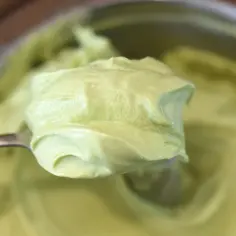 Łyżka nakłada krem pistacjowy z mascarpone. Delikatna, zielona masa rozpływa się na łyżce, zapowiadając pyszny deser.