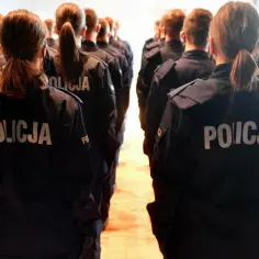 Grupa osób w mundurach z napisem "POLICJA" stoi w szeregu. To może być początek drogi, jak dostać pracę w policji.