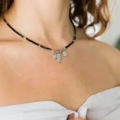Elegancki srebrny naszyjnik damski z czarnymi kamieniami i zawieszkami.