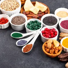 Różnorodne superfoods: nasiona, jagody goji, spirulina, kurkuma, orzechy i inne. Wśród nich proszek z alg, bogaty w **fosfor**.