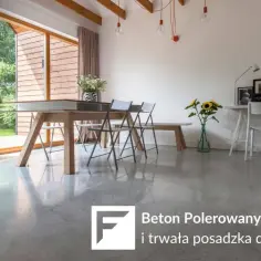 Nowoczesne wnętrze z dużymi oknami i stołem, na którym króluje beton polerowany.