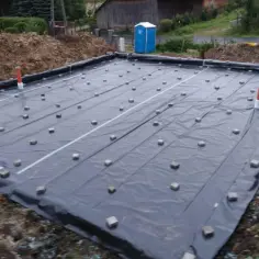 Fundament budowlany z folią, dystansami i rurami.