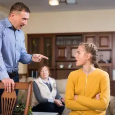 Ojciec krzyczy na córkę, wskazując palcem. Czy można kogoś wyrzucić z mieszkania? Babcia patrzy z boku.