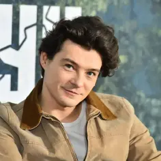 Tomasz Ziętek w brązowej kurtce, z charakterystyczną fryzurą, gotowy do kolejnych filmów.