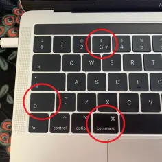 Klawiatura MacBook Air z zaznaczonymi klawiszami Shift, Command i 3.
