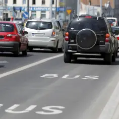 Samochody stoją w korku na pasie z napisem BUS.