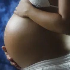 Brzuch kobiety w ciąży, delikatnie dotykany dłońmi. Warto pamiętać o bezpieczeństwie i konsultować przyjmowanie leków, np. ibuprofen w ciąży, z lekarzem.