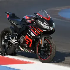 Czarna Aprilia RS 125 z czerwonymi akcentami na torze, gotowa do bicia rekordów w przyspieszeniu 0-100.