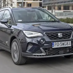 Ciemnoniebieski Seat Arona w ruchu miejskim. Zastanawiasz się, seat arona jaki silnik wybrać? Ten model oferuje różne opcje napędu.
