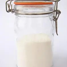 Słoik z proszkiem do pieczenia. Zastanawiasz się, ile proszku do pieczenia na kilogram mąki?