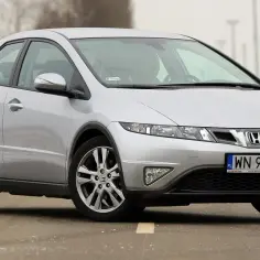 Srebrny Honda Civic, z charakterystycznym kształtem przypominającym UFO, jedzie po drodze.