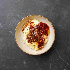Kremowe puree ziemniaczane polane pikantnym, czerwonym chipotle sosem z dodatkiem płatków chili.