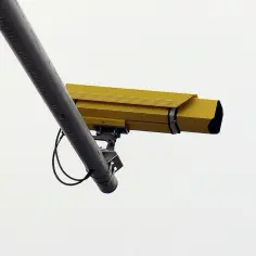 Żółta kamera rejestrująca odcinkowy pomiar prędkości S8 czuwa nad bezpieczeństwem kierowców.