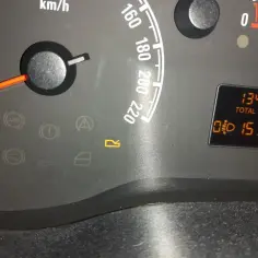 Kontrolki w Oplu: ABS, hamulec ręczny, ciśnienie oleju, poduszka powietrzna, drzwi, bagażnik. Na wyświetlaczu 134696 km i czas 15:30.
