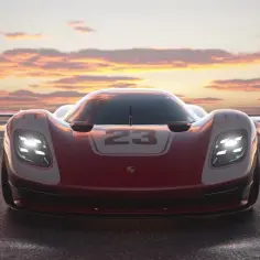 Wyścigowe Porsche z numerem 23 na masce, gotowe do startu w Gran Turismo 8. Zachód słońca maluje niebo.