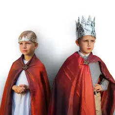Dwóch chłopców w błyszczących płaszczach i koronach, gotowych na bal przebierańców świętych.
