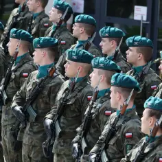 Żołnierze w zielonych beretach i mundurach stoją w szeregu, gotowi na przyszłe wyzwania. Podwyżki dla wojska w 2026 roku to ważny krok.
