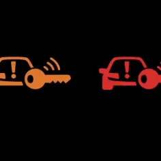 Pomarańczowa i czerwona kontrolka samochód z kluczykiem Opel: brak kluczyka w zasięgu lub problem z immobilizerem.