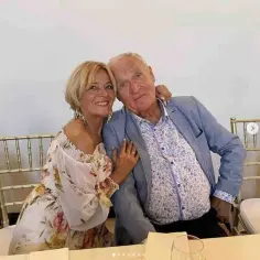 Gerard Makosz z żoną, uśmiechnięci, siedzą przy stole. Widać ich majątek i szczęście.