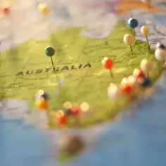 Kolorowe pinezki na mapie Australii. Zastanawiasz się, ile trwa lot do Australii z Polski?
