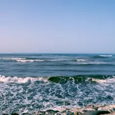 Spienione fale rozbijają się o kamienisty brzeg. Czy morze kaspijskie jest słone? Tak, jego wody są słone, choć mniej niż oceaniczne.