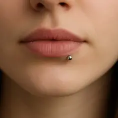 Zbliżenie na usta z kolczykiem labret. Dowiedz się, jak odkręcić kolczyk labret, gdy potrzebujesz go wymienić.