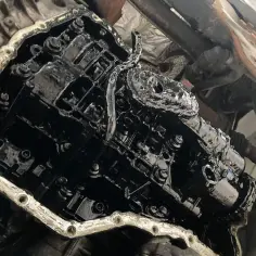 Wnętrze silnika Volvo 2.5 turbo po awarii. Widoczne elementy układu rozrządu pokryte czarnym osadem.