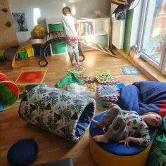 Dzieci bawią się na torze przeszkód dla dzieci przykłady: tunel, ścieżka sensoryczna, zjeżdżalnia.