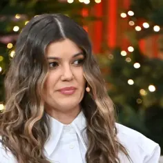 Marta Surnik w białej koszuli, z burzą brązowych loków, na tle świątecznych światełek. Czyżby wspominała męża?