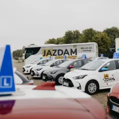 Samochody szkoleniowe "Ja Zdam" z literką L na dachu. Szkoła jazdy działa od lat, pomagając zdobyć prawo jazdy.