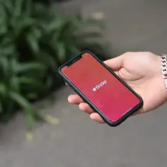 Dłoń trzyma smartfon z logo Tindera. Chcesz wiedzieć, jak usunąć konto na Tinderze?