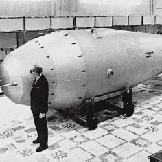 Mężczyźni w garniturach oglądają gigantyczną bombę, która jest symbolem potęgi – car bomba.