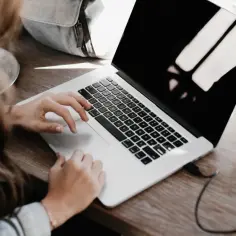 Kobieta pracuje na laptopie, szukając sposobów, jak bezpiecznie ukryć przed obecnym szefem szukanie nowej pracy.