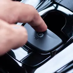 Palec naciska przycisk hamulca ręcznego elektrycznego. Dowiedz się, jak używać hamulca ręcznego elektrycznego.