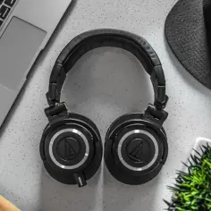 Słuchawki nauszne, laptop i czapka. Idealny zestaw do tworzenia muzyki i tworzenia rankingu słuchawek nausznych.