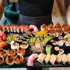 Ogromna taca z różnorodnym sushi: rolki z łososiem, tuńczykiem, krewetkami, nigiri i maki. To idealna odpowiedź na pytanie: co to jest sushi.