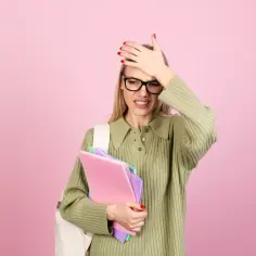 Zmartwiona studentka z teczkami, która zapomniała o terminie oddania pracy. Nieklasyfikowanie dziecka w zerówce to stresująca sytuacja.
