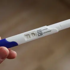 Test ciążowy z dwoma kreskami, wskazujący na pozytywny wynik. To ważny moment dla osób starających się o dziecko, często po in vitro, gdy monitoruje się normy beta hcg.