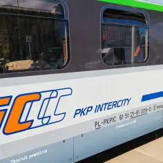 Pociąg PKP Intercity, idealny na podróż przez miasto na trasie Piła Chojnice. Widać bagaż i pasażerów przez okno.