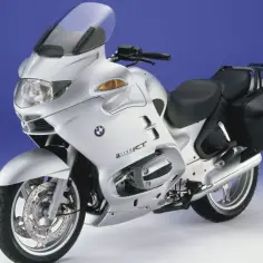 Srebrny motocykl turystyczny BMW R 1150 RT z czarnymi kuframi, gotowy na dalekie podróże.