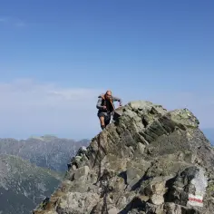 Wspinacz na skalistym szczycie, podziwia widok na Tatry. Czy to już Rysy?