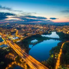 Wieczorne światła rozświetlają miasto, a autostrada przecina malowniczą Dolinę Trzech Stawów w Katowicach.